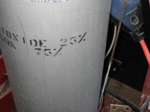 1985 Ford F-350 - A gray gas cylinder displays stenciled percentages and is connected to electrical components.