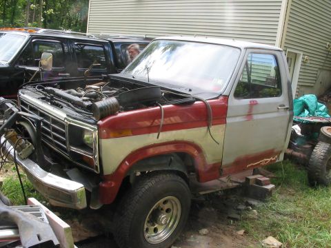 1985 Ford F-350 - This pickup truck, possibly a Ford from the early 1980s, is shown with its hood open, undergoing some work.