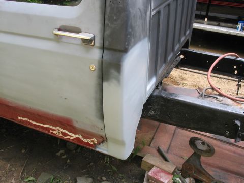 1985 Ford F-350 - This 1980s Ford F-350 cab shows rust damage and primer on the lower door and fender area.