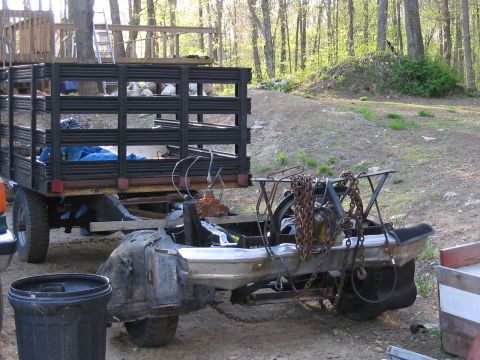 1985 Ford F-350 - This scene shows a trailer carrying a disassembled vehicle frame and various parts, with a trash can nearby.