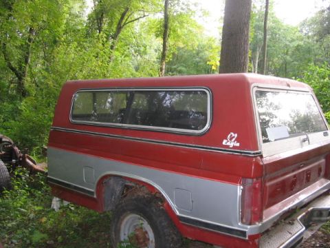 1985 Ford F-350 - Pickup truck with a camper shell, parked outdoors. The truck features a two-tone red and silver paint scheme.