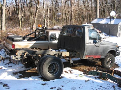 1985 Ford F-350 - Two trucks are parked in a snowy outdoor area, one appears to be a chassis cab and the other has a pickup bed.
