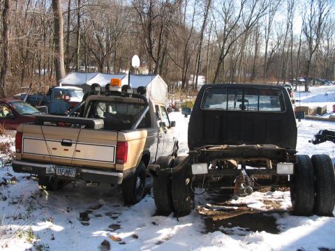 1988 Ford Ranger - A 1988 Ford Ranger pickup truck is seen from the rear, parked next to another truck chassis in a snowy outdoor setting.
