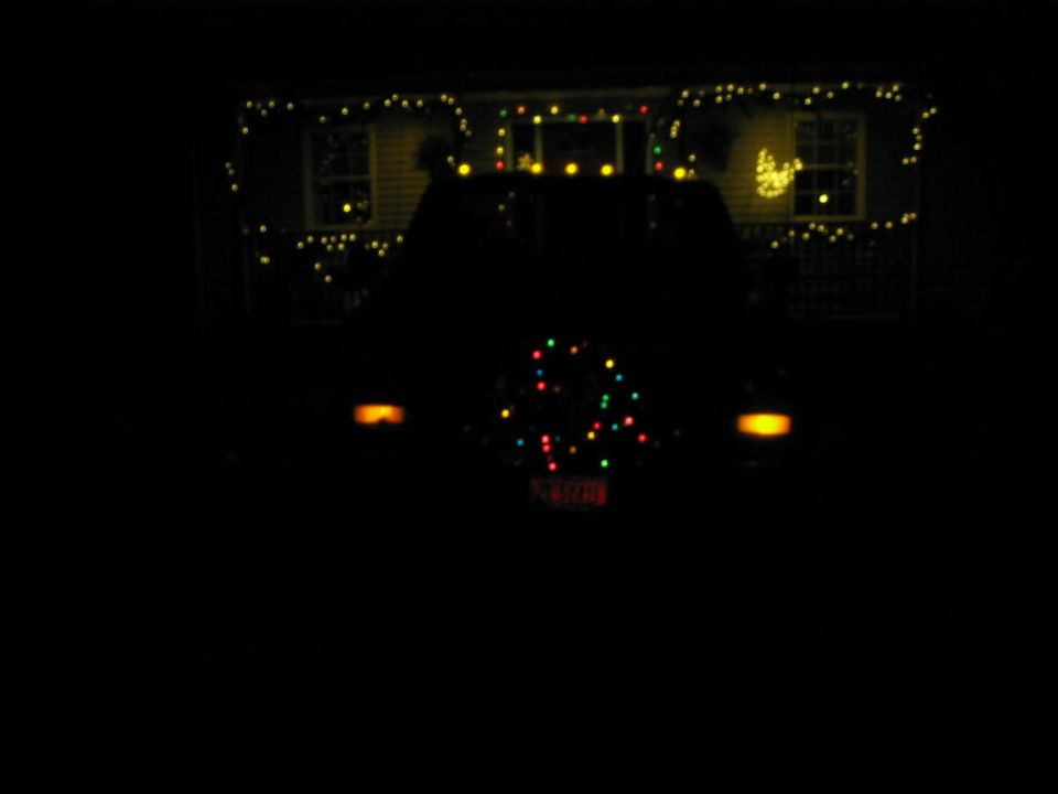 Rear of SUV decorated with Christmas lights, spare tire cover has lights