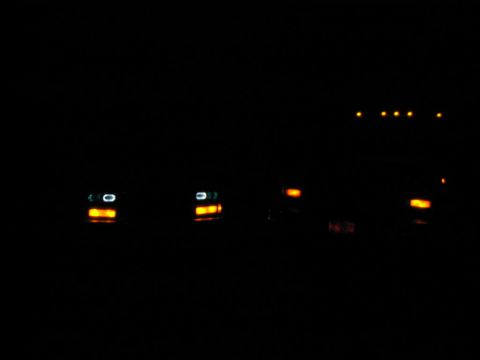 1985 Ford F-350 - Two trucks are visible at night, with headlights and marker lights illuminated.