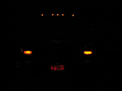 1985 Ford F-350 - Truck's rear lights are on at night, license plate is visible.