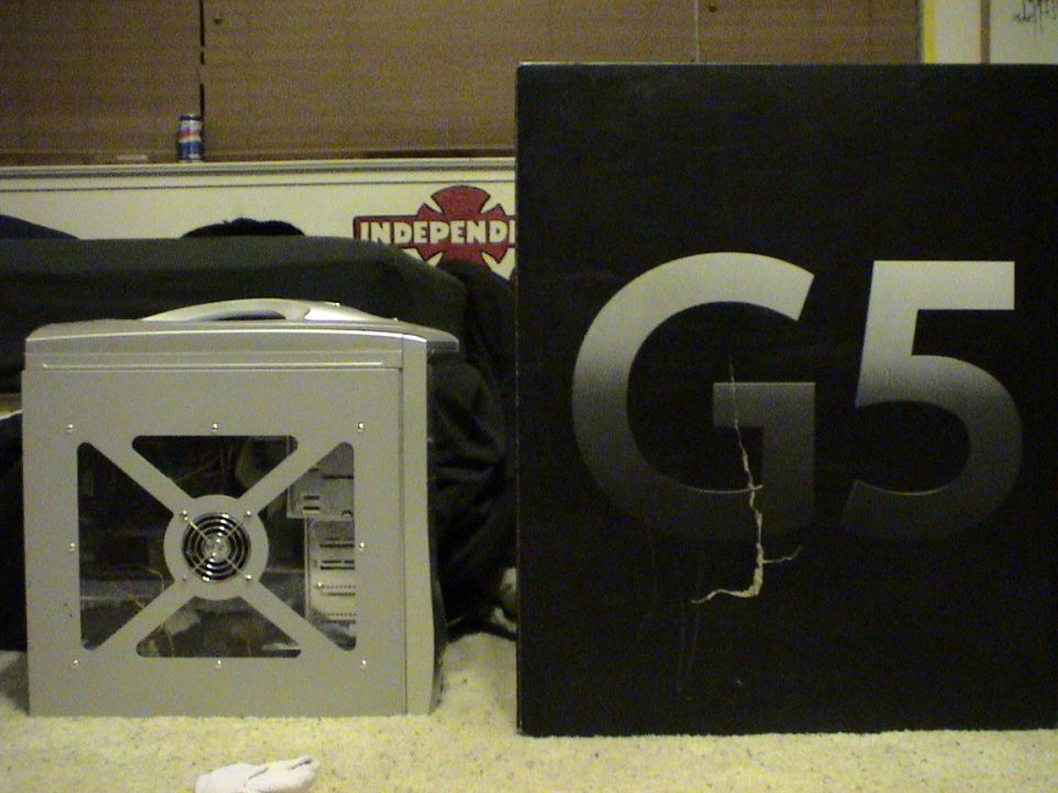 Silver computer tower with clear side panel next to a black box with 'G5' printed on it