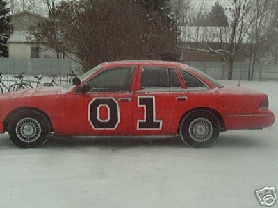 2000 Ford Crown Victoria - A red sedan, resembling the General Lee from The Dukes of Hazzard, is seen in a snowy environment with the number "01" prominently displaye…