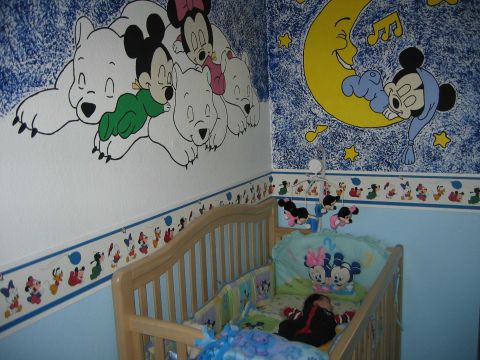 2002 Ford Taurus - A baby sleeps in a crib decorated with Disney characters and themed wall art.