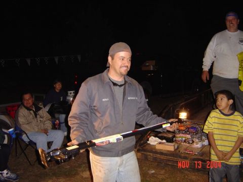 1978 Ford Bronco - An outdoor gathering at night with several people present, including a man holding a long, decorated object.