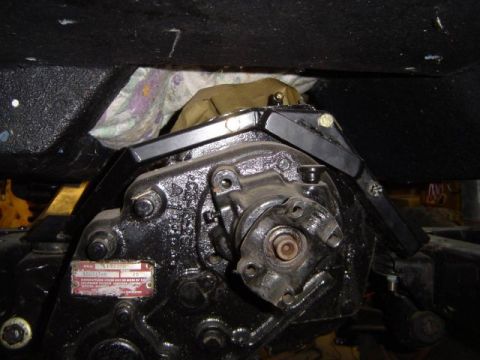 1971 Ford Bronco - Close-up of a vehicle's transmission and transfer case, with a red data plate attached.