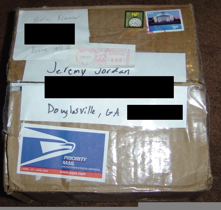 Cardboard box with Priority Mail label and handwritten addresses