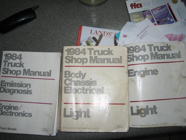 Three 1984 Ford Truck Shop Manual volumes laid out on a countertop