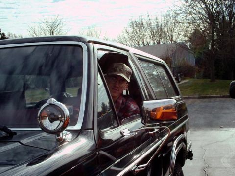 1984 Ford Bronco - A person is visible inside a Ford Bronco, looking out the driver's side window.