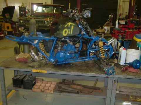 1992 Ford Crown Victoria - ATV frame and engine on a workbench in a garage setting.