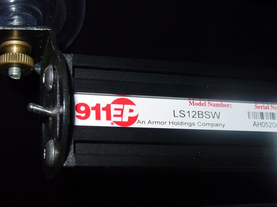 Label on black 911EP LS12BSW light bar with mounting bracket and brass thumbscrew