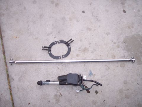 1995 Ford Probe - A car antenna assembly, including the mast and motor, is shown disassembled on a concrete surface.