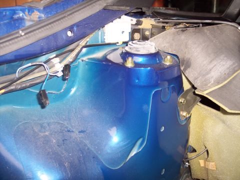 1995 Ford Probe - Close-up view of a car's blue metallic strut tower and surrounding engine bay components.