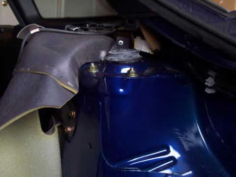 1995 Ford Probe - Close-up view of a blue vehicle's strut tower assembly, showing bolts, wiring, and part of the interior trim. The Supermotors.net logo is v…