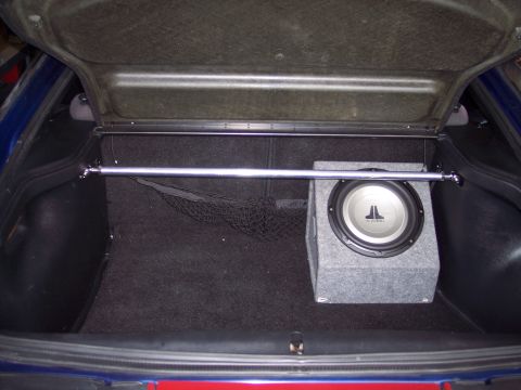 1995 Ford Probe - Trunk interior features a JL Audio subwoofer and a chrome strut bar, suggesting aftermarket modifications.