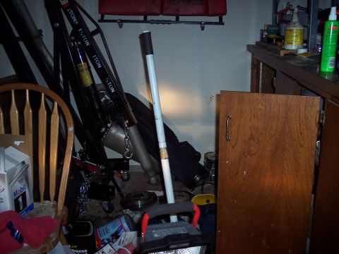 1995 Ford Probe - A cluttered workshop scene contains an engine hoist, a wooden chair, and cabinets, with various tools and supplies visible.