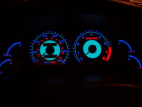 1995 Ford Probe - The illuminated dashboard gauges display speed and engine RPM in the dark interior of a vehicle.