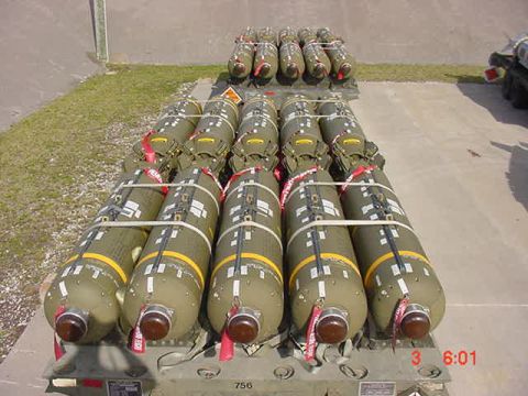 1981 Ford Bronco - Multiple rows of ordnance are prepared for transport on a flatbed trailer.