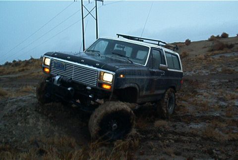 1986 Ford Bronco - This Ford Bronco appears to be from the early 1980s, not 1986, as it navigates a muddy off-road course.