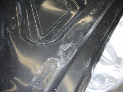 1993 Ford Taurus - Close-up of a black plastic automotive interior component, showing molded details and some white residue.