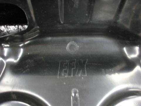 1993 Ford Taurus - Close-up of a black plastic automotive part showing embossed text.