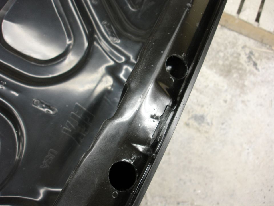 Black metal part with stamped 'USA' and 'GM' logos