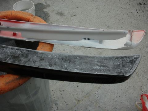 1993 Ford Taurus - A carbon fiber automotive part is shown next to a white primed piece, possibly undergoing repair or modification.