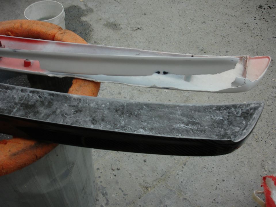 Carbon fiber automotive part with a white primer piece above it