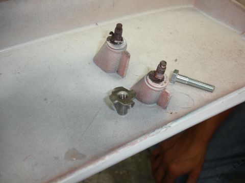 1993 Ford Taurus - Metal brackets, bolts, and a T-nut are laid out on a tray.