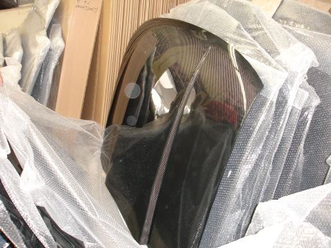 1993 Ford Taurus - A close-up of a carbon fiber automotive part, likely a fender or hood, covered in protective wrapping.