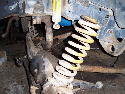1983 Ford Bronco - This image shows a disassembled vehicle suspension system, focusing on the coil spring and shock absorber.