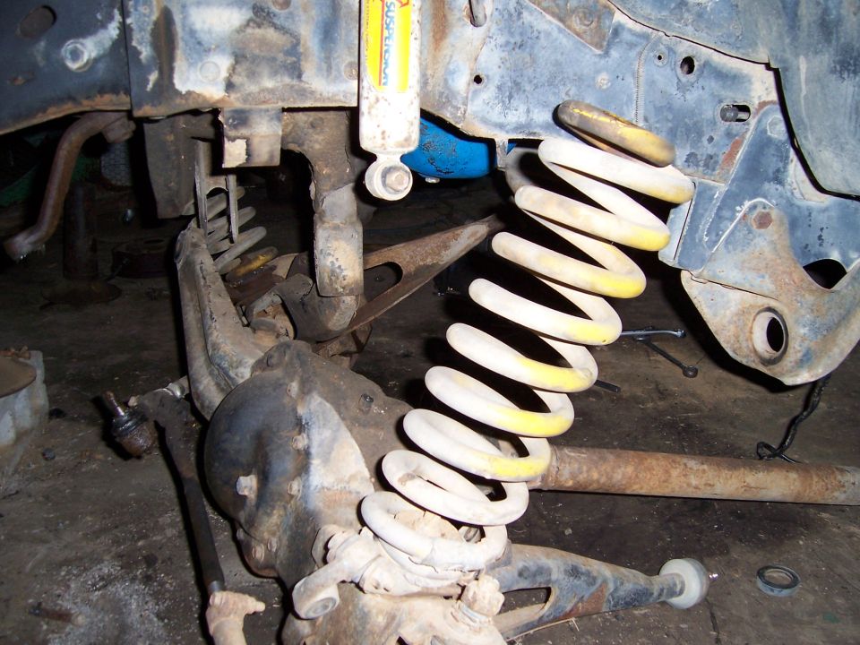 close-up of vehicle suspension parts, including a coil spring and shock absorber