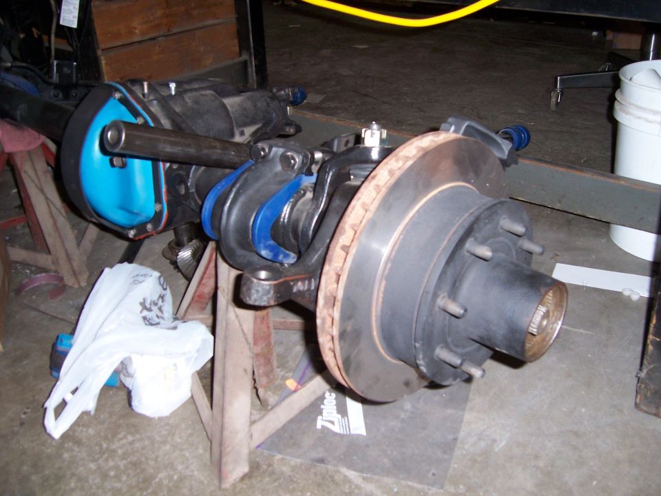 Front axle assembly with disc brake and blue suspension components