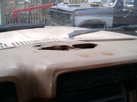 1986 Ford F-250 - The dashboard has significant damage, and another truck is visible outside, partially obscured by a crane.