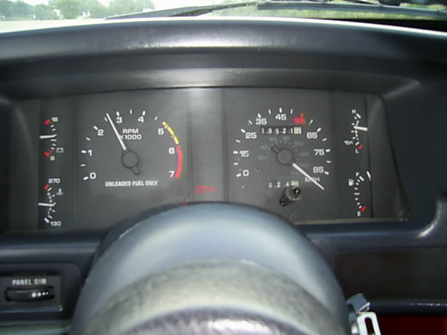Instrument cluster with tachometer and speedometer behind the steering wheel