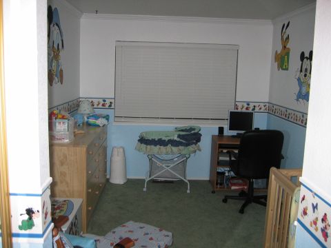 2002 Ford Taurus - A child's bedroom is decorated with cartoon characters and contains a dresser, changing station, and a desk with a computer.