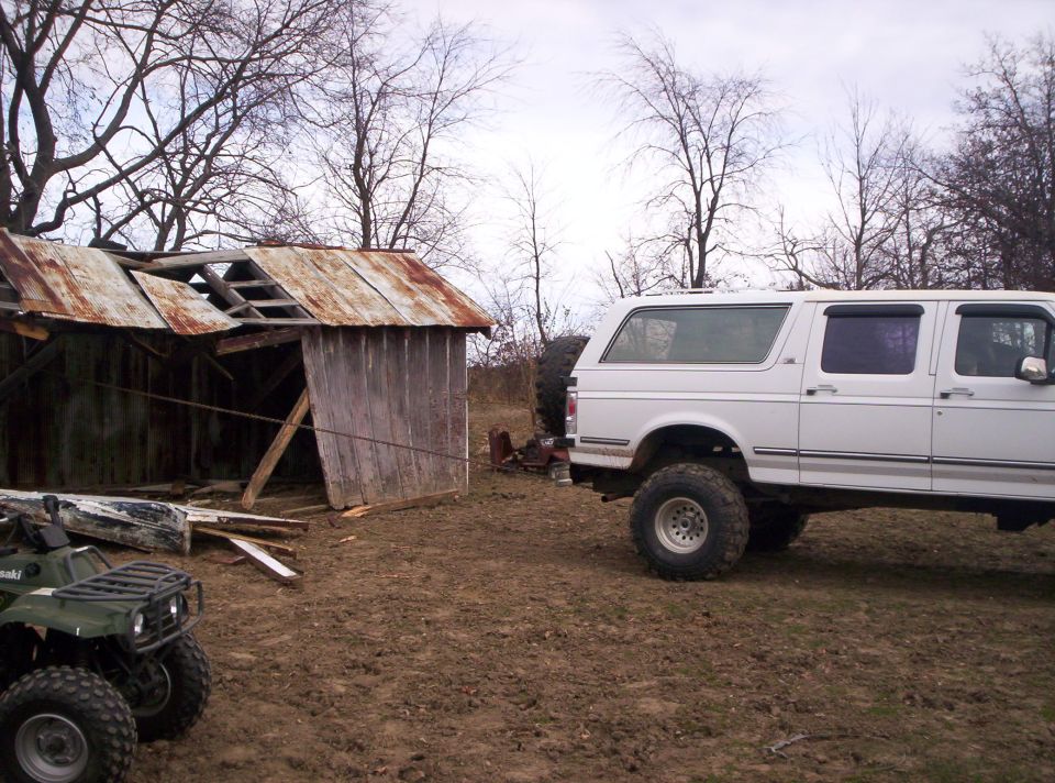 1992 Ford C-150 (Centurion Conversions) parked on muddy ground next to an old shed