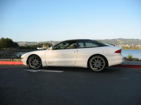 1997 Ford Probe - A white 1997 Ford Probe GT is shown from the side, aftermarket wheels and a scenic backdrop.