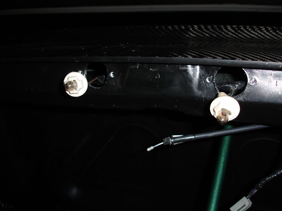 Interior light bulbs and cable against black background with carbon fiber texture above