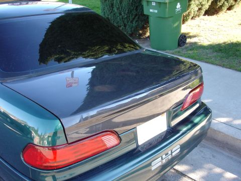1993 Ford Taurus - The rear of a green car shows a carbon fiber trunk lid and a "SHS" emblem.