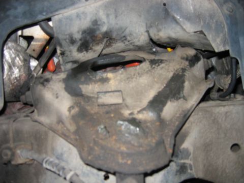 1985 Ford LTD Crown Victoria - This image shows a close-up view of a vehicle's suspension system, focusing on a heavily soiled component.