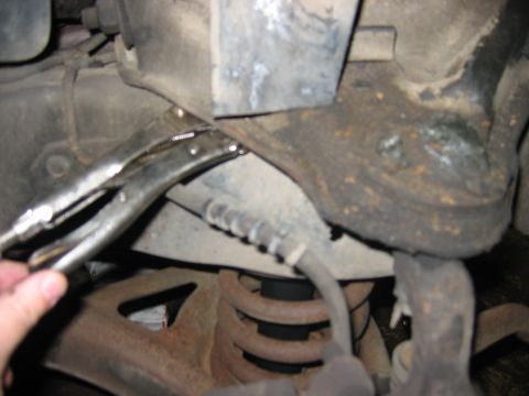 1985 Ford LTD Crown Victoria - A mechanic uses a vise grip on the suspension of a 1985 Ford Crown Victoria LTD.