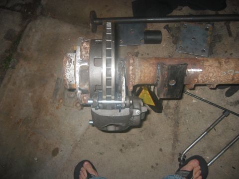 1989 Ford Bronco - Close-up view of a rear axle assembly, showing the brake caliper and rotor attached to the axle housing.