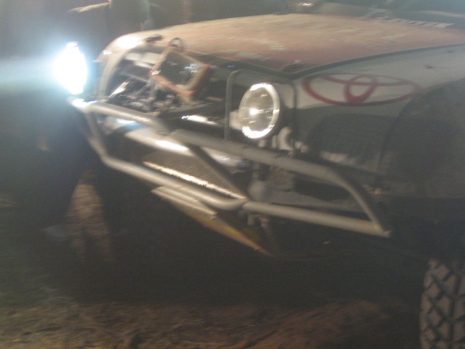 Close-up of an off-road truck front end with tube bumper and Toyota emblem at night