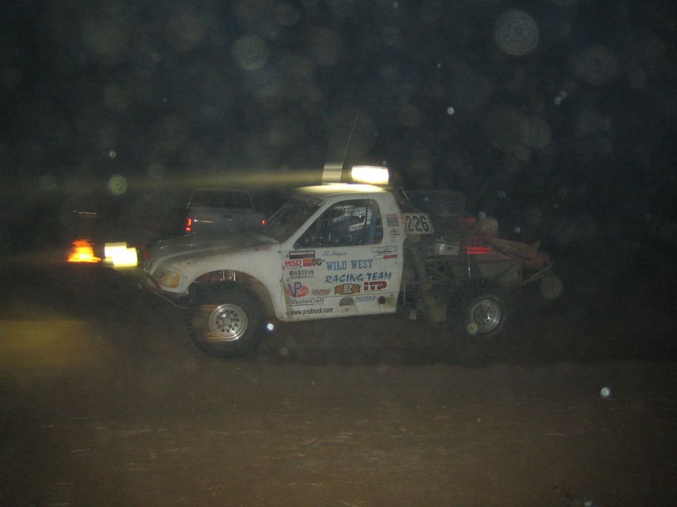 White Wild West Racing Team off-road truck numbered 225 in profile at night